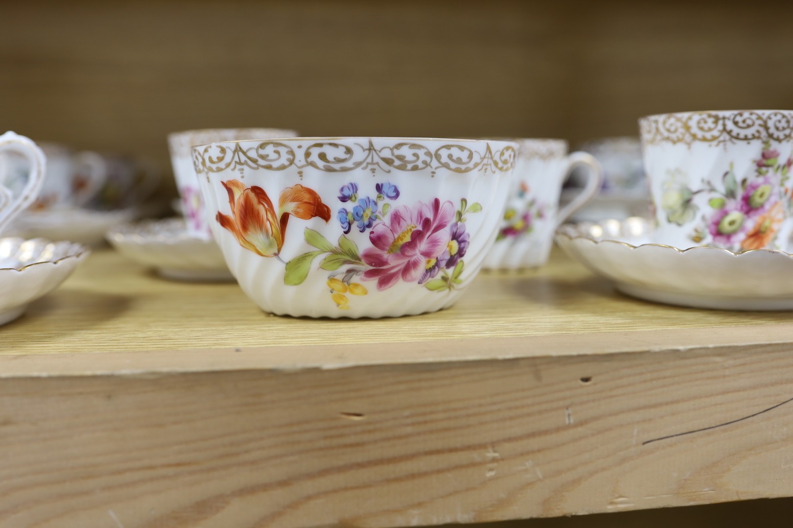 A quantity of Nymphenburg and Dresden porcelain cups and saucers